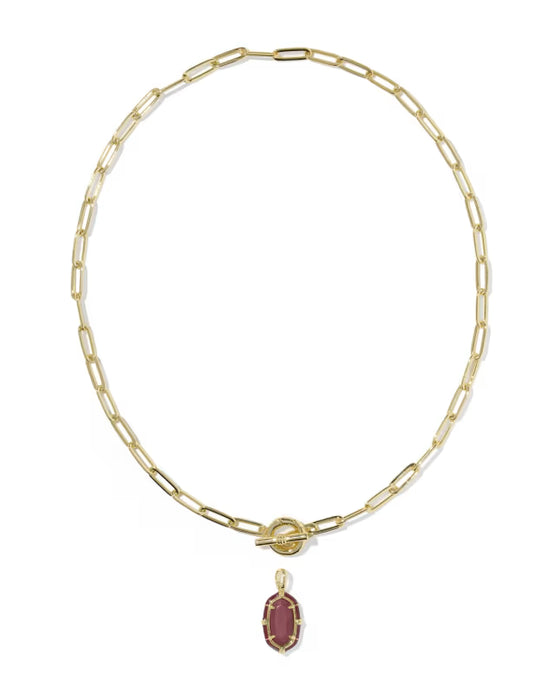 A gold paperclip chain necklace with a toggle clasp and a small oval maroon gemstone pendant, shown on a plain white background.