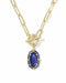 A gold paperclip chain necklace with a toggle clasp and a blue oval pendant, shown on a clean white background.