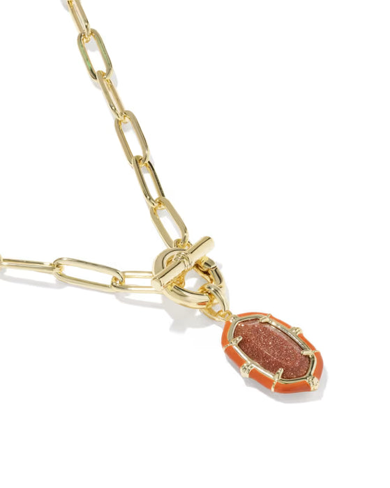 A gold paperclip chain necklace featuring a small pendant with a textured orange-red stone set in gold, shown on a clean white background.