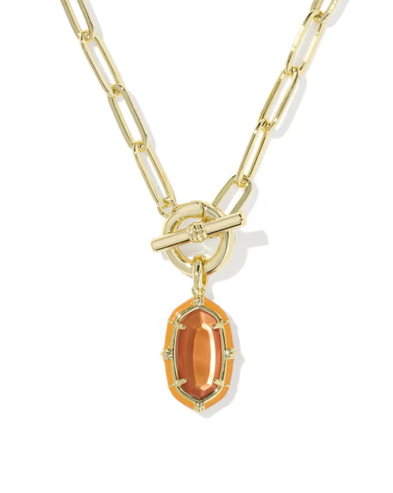 A gold paperclip chain necklace with a toggle clasp and a dangling oval orange gemstone pendant, shown on a clean white background.