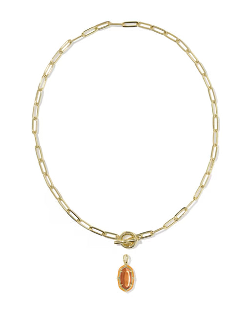 A gold paperclip chain necklace with a toggle clasp and a dangling oval amber gemstone pendant, shown on a plain white background.