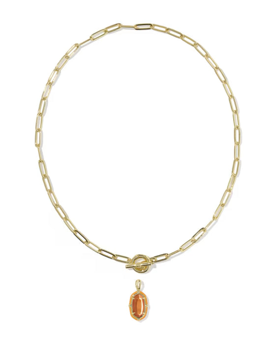 A gold paperclip chain necklace with a toggle clasp and a dangling oval amber gemstone pendant, shown on a plain white background.