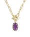 A gold paperclip chain necklace with a toggle clasp and a purple oval gemstone pendant, shown on a clean white background.