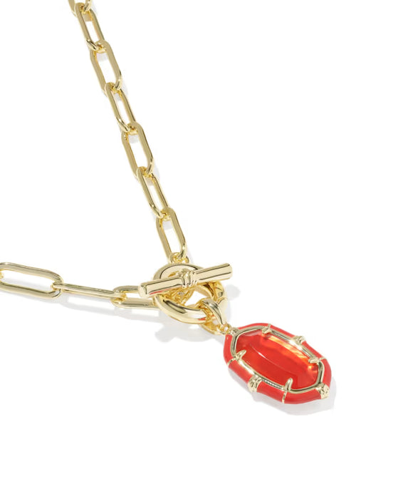 A gold paperclip chain necklace with a toggle clasp and a dangling red enamel pendant, shown on a clean white background.