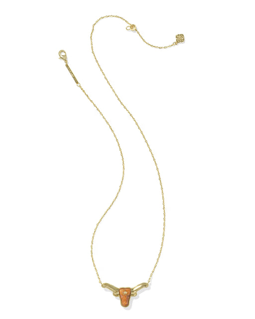 A delicate gold chain necklace featuring a small, stylized longhorn pendant with a textured orange center, displayed on a clean white background.