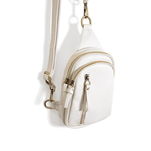 White crossbody bag with gold zippers on a white background