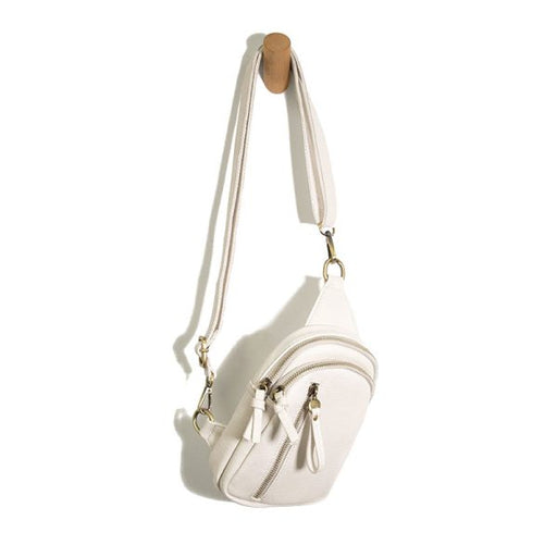 White crossbody bag with gold accents on a white background