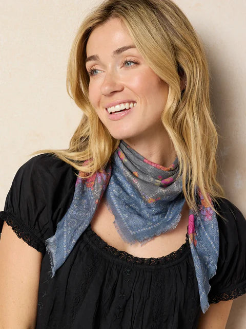 Woman wearing a colorful scarf against a plain background