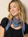 Woman wearing a colorful scarf against a plain background