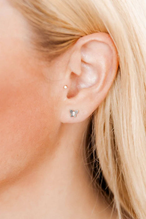 Close-up of a person wearing a small silver earring.