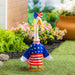 Decorative goose wearing an American flag outfit in a garden setting