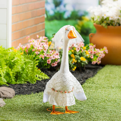 Decorative goose figurine with a white lace cover in a garden setting