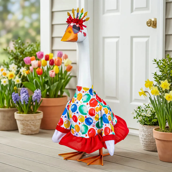 Decorative goose with colorful pattern on a wooden deck with potted plants.