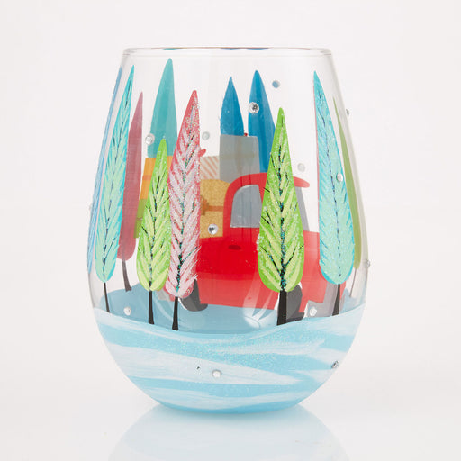 Decorative wine glass with a colorful winter scene of trees and a house on a white background