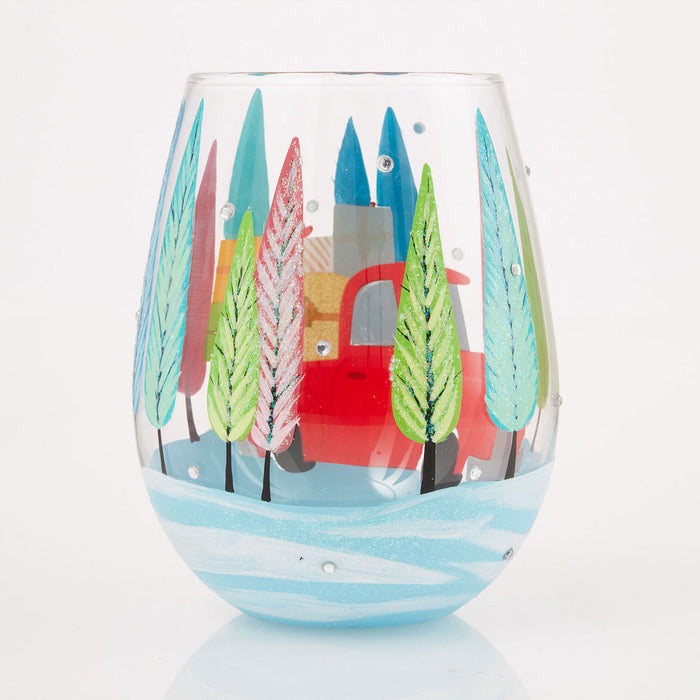 Decorative wine glass with a colorful winter scene of trees and a house on a white background