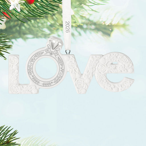 Decorative ornament with 'love' and a ring design, hanging on a tree branch.