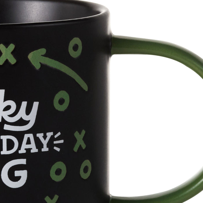Black mug with green and white text and symbols on a white background