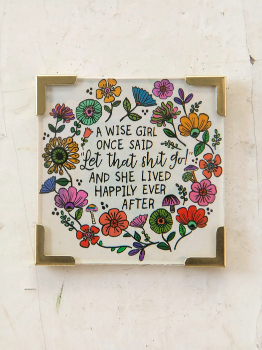 Decorative sign with floral design and humorous quote on a light background