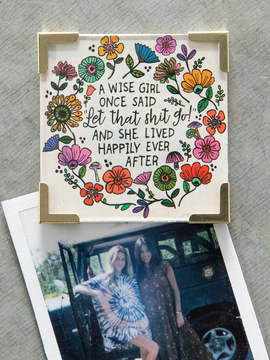 Decorative sign with floral design and quote on a gray surface