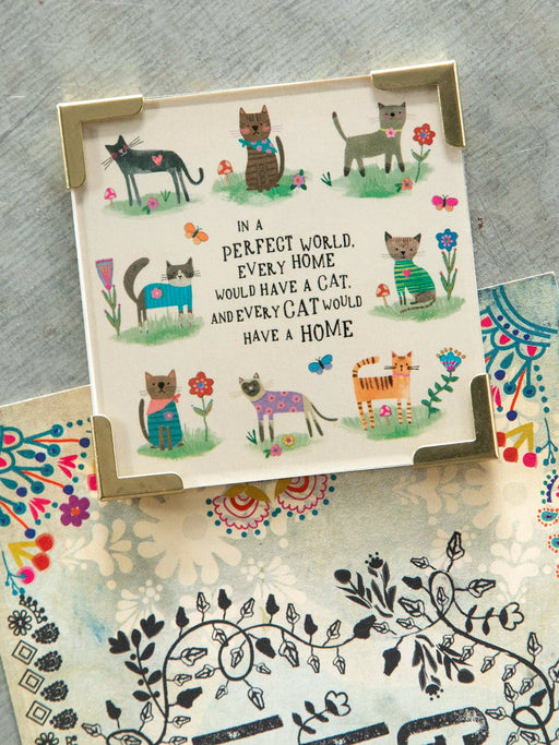 Card with cat illustrations and a quote on a textured surface