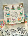 Card with cat illustrations and a quote on a textured surface