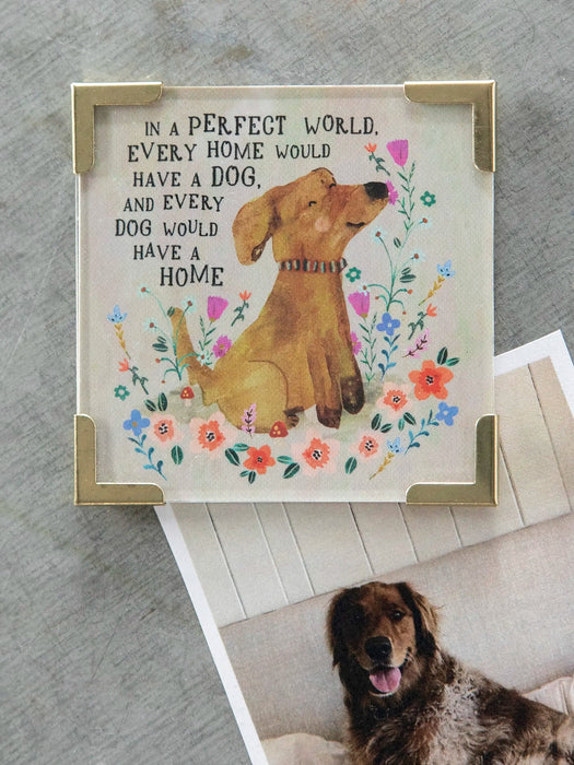 Decorative sign with a dog illustration and text, placed on a surface with a dog photo below.