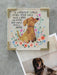 Decorative sign with a dog illustration and text, placed on a surface with a dog photo below.