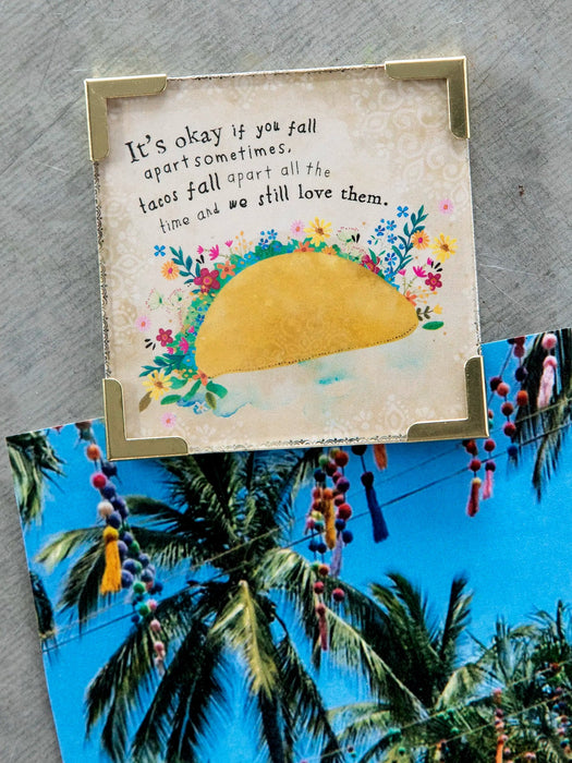Card with a taco illustration and motivational quote on a textured surface