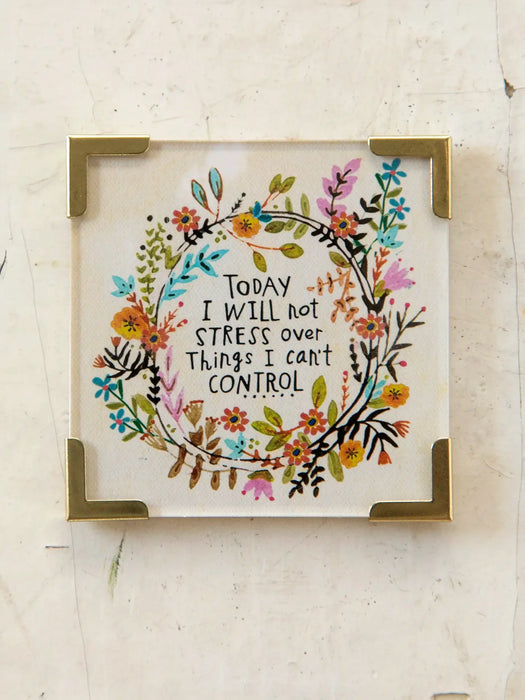Decorative sign with floral design and motivational quote on a light background