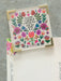 Floral card with motivational quote on a gray surface