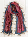 Patterned scarf with tassels on a wooden surface