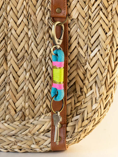 Woven bag with a colorful keychain featuring keys and a small pouch.