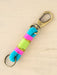 Keychain with colorful strap and gold carabiner on beige background