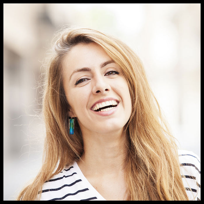Woman with long blonde hair smiling outdoors
