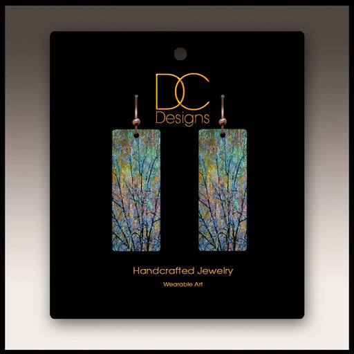 Pair of earrings on a black card with 'DC Designs' branding