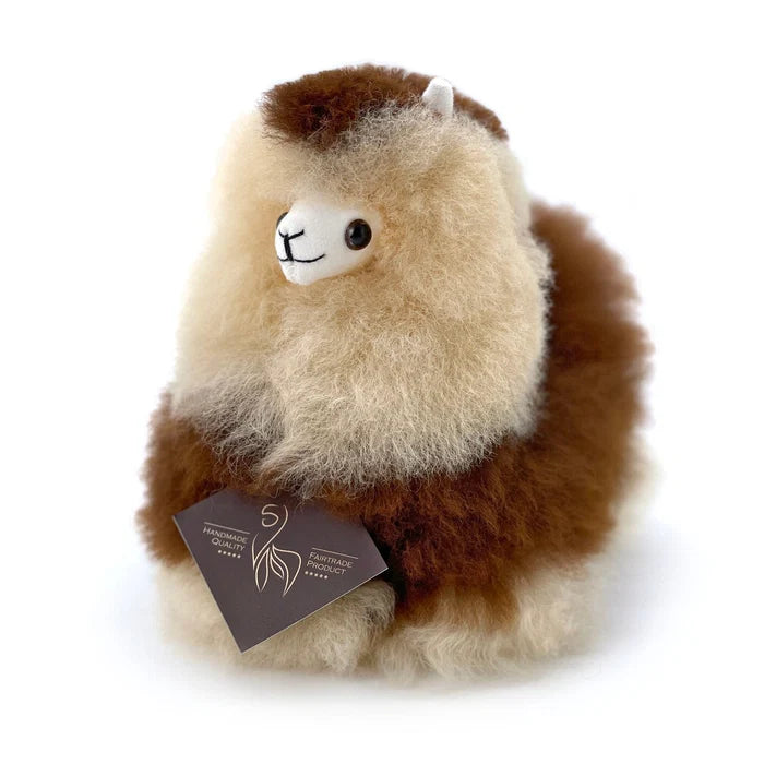A fluffy alpaca plush toy with a cream and brown color scheme, featuring a white face and a dark brown hangtag attached, set against a plain white background.