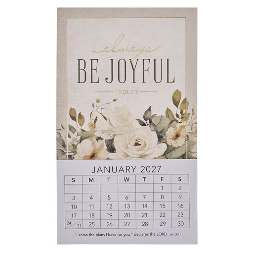 A vertical wall calendar page with a beige top section reading “always BE JOYFUL” and “January 2027,” decorated with cream flowers and green leaves, and a white lower section showing the calendar grid.