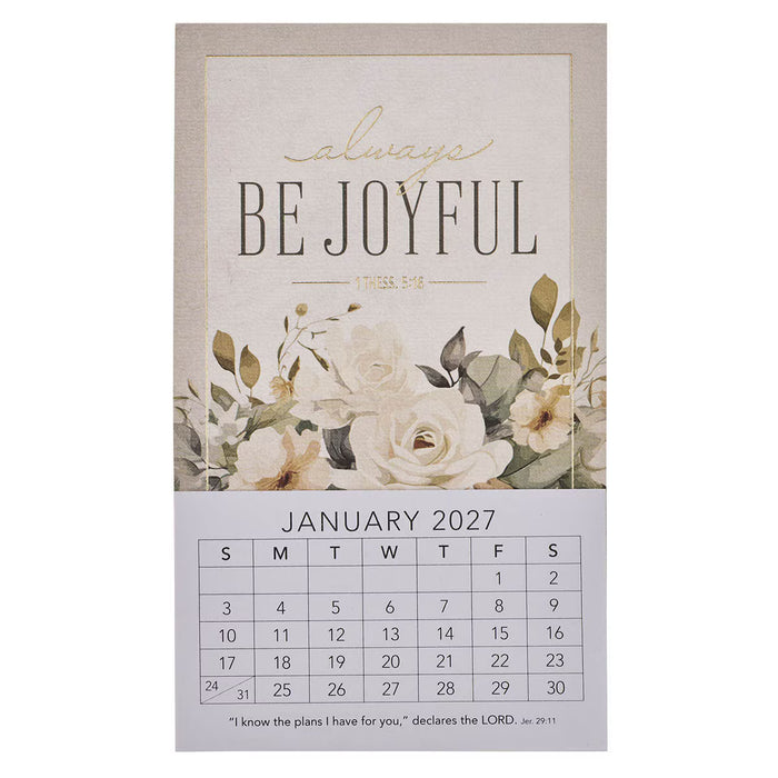 A vertical wall calendar page with a beige top section reading “always BE JOYFUL” and “January 2027,” decorated with cream flowers and green leaves, and a white lower section showing the calendar grid.