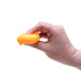 Hand holding an orange object against a white background