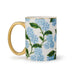 Mug with floral design and gold handle on a white background