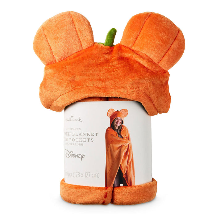 An orange plush hooded blanket with Mickey Mouse-style ears and a small green stem detail, wrapped around a white cylindrical cardboard display insert featuring Disney and Hallmark branding.