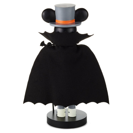 A decorative tabletop figure styled like a character wearing a black bat-wing cape, a gray top hat with black ears, and an orange band, standing on a round black base against a plain white background.