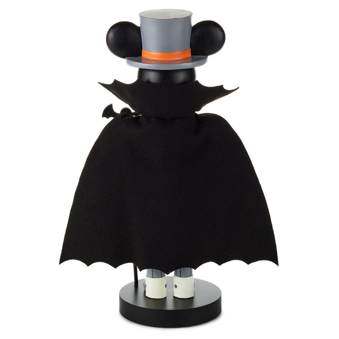 A decorative tabletop figure styled like a character wearing a black bat-wing cape, a gray top hat with black ears, and an orange band, standing on a round black base against a plain white background.