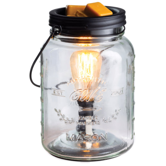 Mason jar candle warmer with a lit bulb inside on a white background