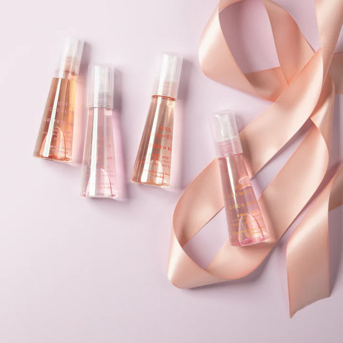 Set of skincare bottles with a pink ribbon on a light pink background