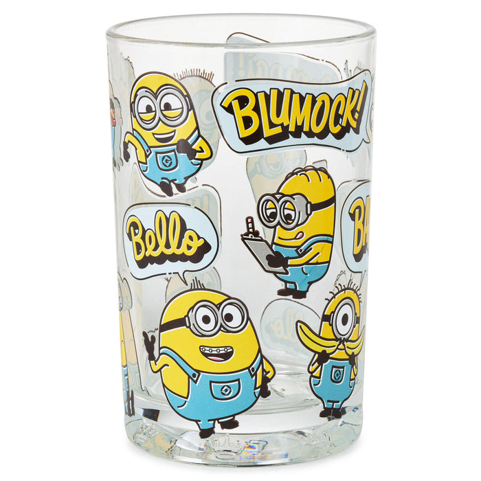 A clear glass tumbler featuring cartoon Minions characters and the words 'BLUMOCK!' and 'Bello' in bold yellow lettering, shown on a plain white background.