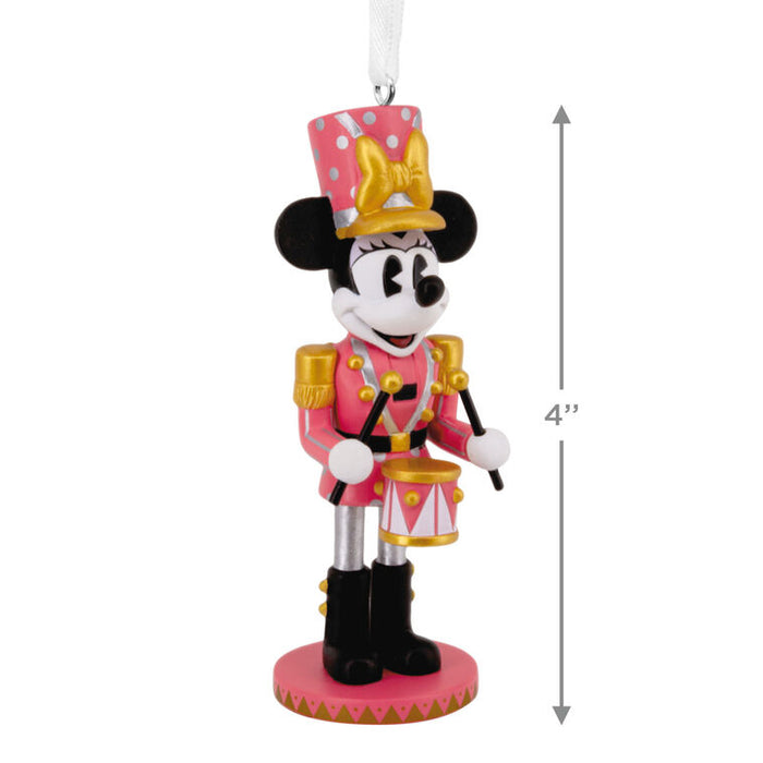 A Minnie Mouse toy nutcracker ornament in a pink and gold military uniform with a pink polka-dot hat, shown on a white background with a 4-inch height measurement arrow.
