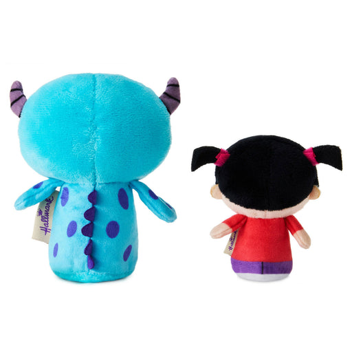 Two plush toys, one blue with purple accents and the other with black hair and a red outfit, on a white background.