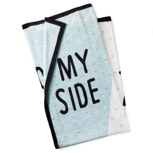 Folded towel with 'MY SIDE' text on a light blue and white patterned background