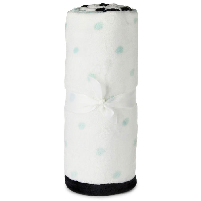 Folded blanket with blue polka dots on a white background